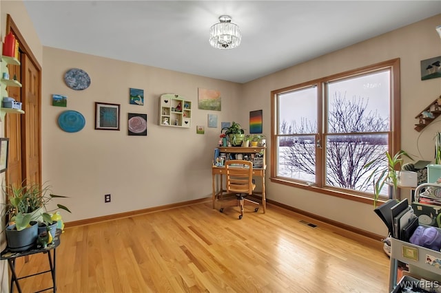 interior space featuring visible vents, baseboards, light wood-style floors, and a chandelier