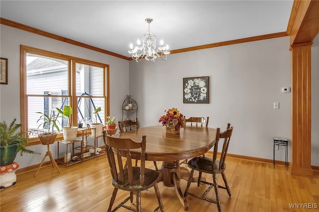 dining area with light wood finished floors, baseboards, a chandelier, ornamental molding, and ornate columns