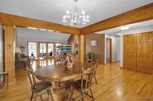 dining space featuring french doors, baseboards, an inviting chandelier, and light wood finished floors