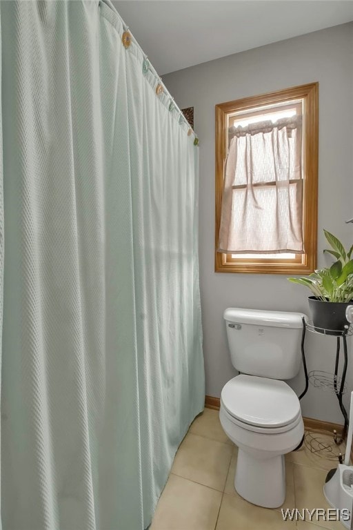 full bath with tile patterned flooring, toilet, and baseboards