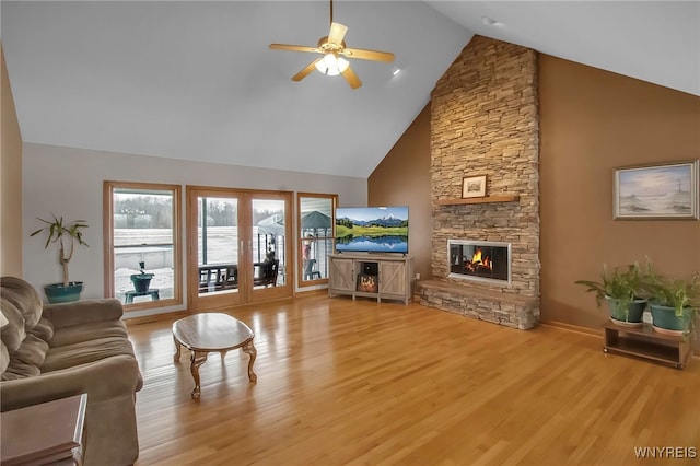 living room with wood finished floors, high vaulted ceiling, a fireplace, and ceiling fan