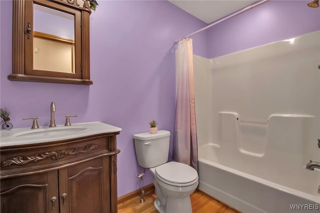 bathroom with shower / tub combo with curtain, toilet, wood finished floors, baseboards, and vanity