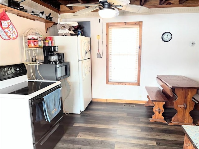 kitchen with dark wood-style flooring, visible vents, baseboards, electric stove, and freestanding refrigerator