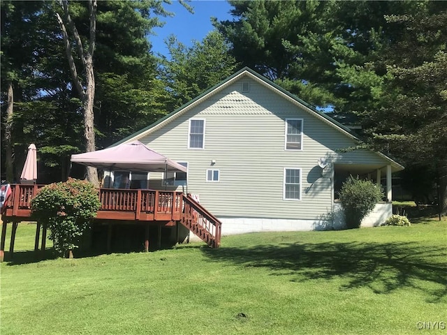 rear view of property with stairway, a lawn, a deck, and a gazebo