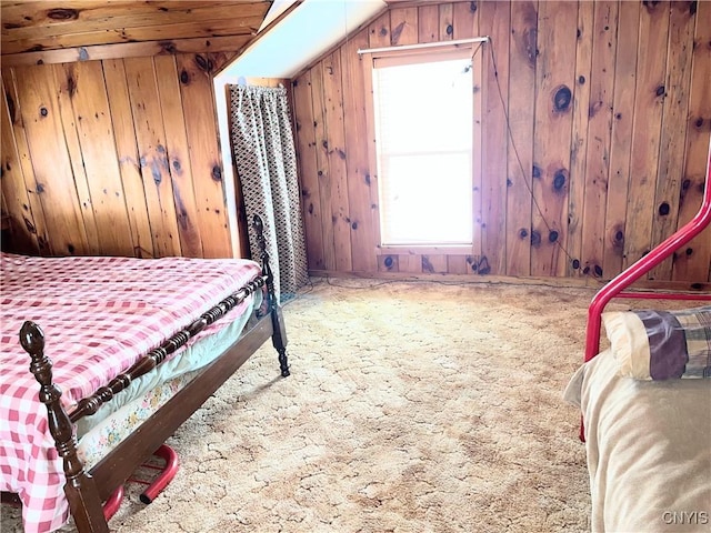 bedroom featuring carpet floors, vaulted ceiling, and wooden walls