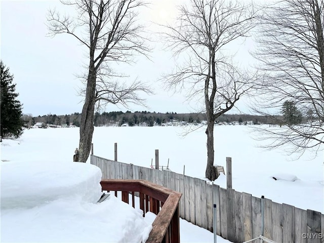 yard covered in snow featuring fence