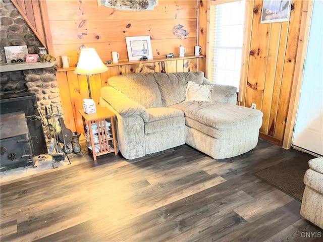 living room featuring wood walls, wood finished floors, and a wood stove