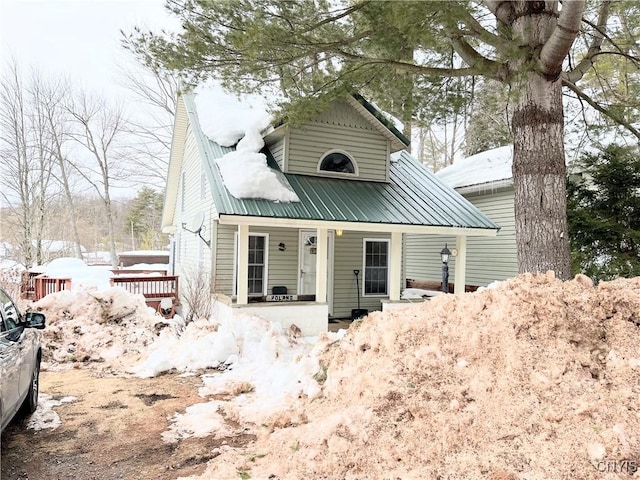 bungalow-style house featuring covered porch and metal roof