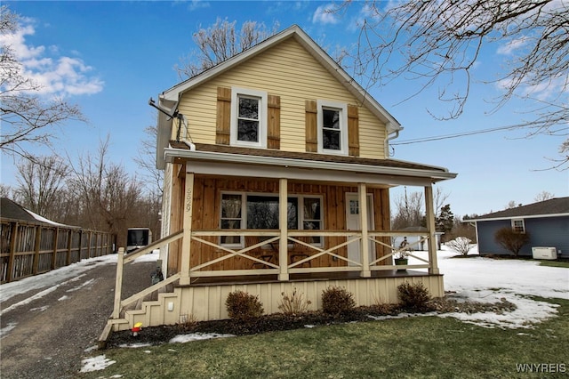 view of front of home with a porch and fence