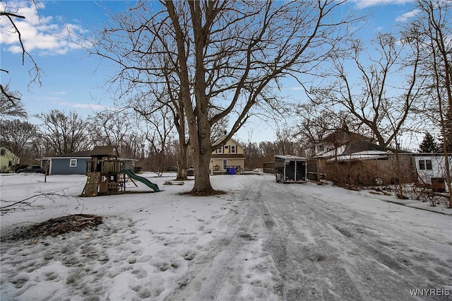 yard covered in snow featuring a playground