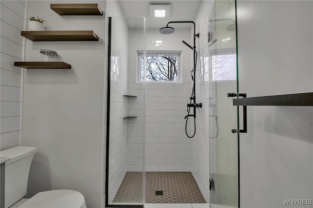 full bath featuring a stall shower and toilet