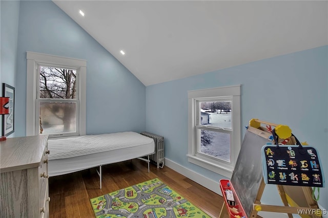 bedroom featuring lofted ceiling, dark wood-type flooring, baseboards, and radiator