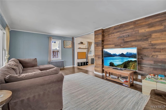 living room with baseboards, crown molding, radiator heating unit, and wood finished floors