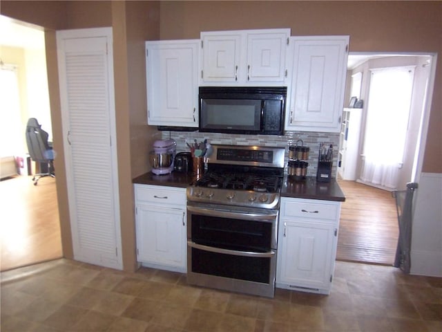 kitchen with black microwave, decorative backsplash, dark countertops, double oven range, and white cabinetry