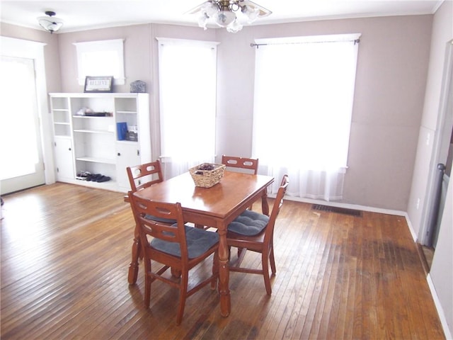 dining space with ceiling fan, hardwood / wood-style floors, visible vents, and baseboards