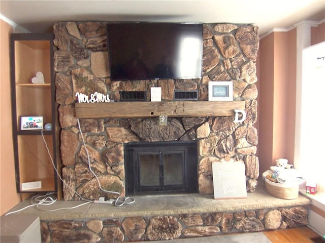 interior details with ornamental molding, a fireplace, and wood finished floors