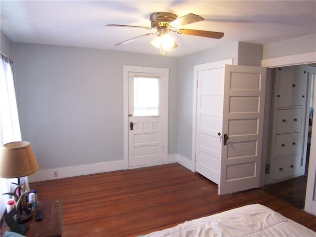 unfurnished bedroom with a ceiling fan, baseboards, and wood finished floors