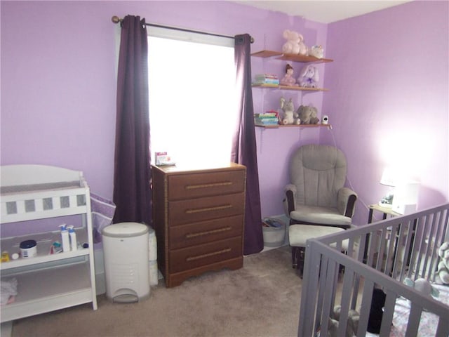 carpeted bedroom featuring a crib