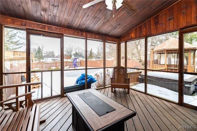 sunroom with lofted ceiling, wooden ceiling, and a ceiling fan