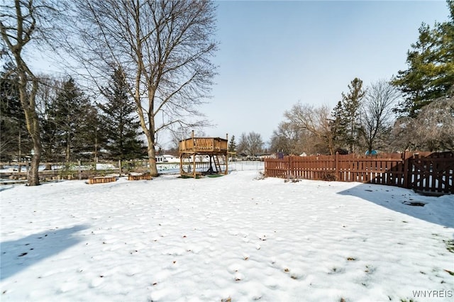 yard covered in snow with fence and a deck