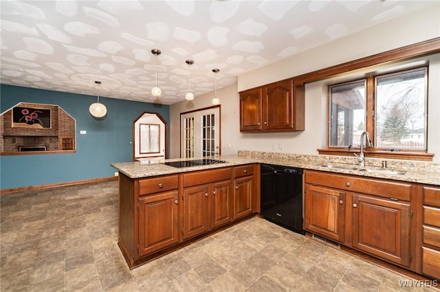 kitchen with a peninsula, a sink, light stone countertops, black appliances, and brown cabinetry