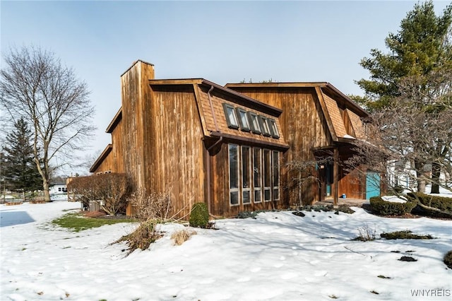 view of snow covered exterior featuring a chimney