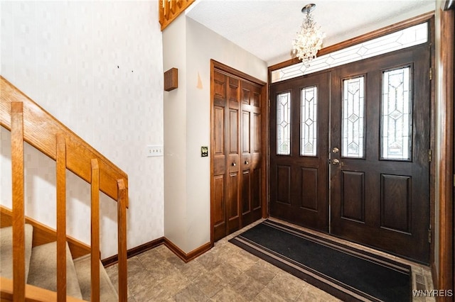 entrance foyer with baseboards, wallpapered walls, an inviting chandelier, and a healthy amount of sunlight