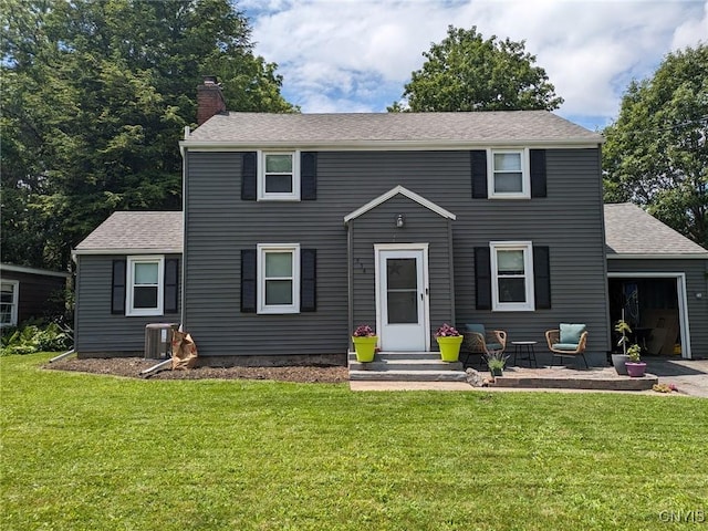 colonial home with a garage, central AC unit, a chimney, roof with shingles, and a front lawn