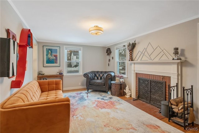 living area with baseboards, a brick fireplace, wood finished floors, and crown molding