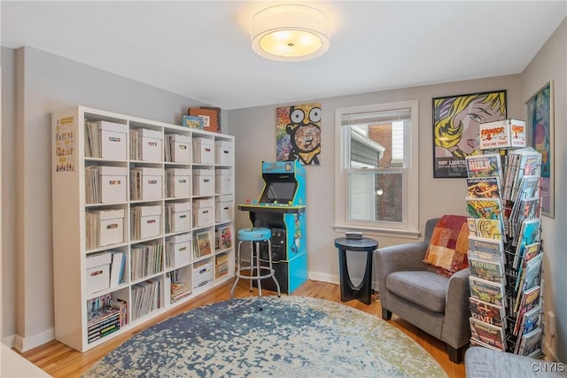 living area with baseboards and wood finished floors