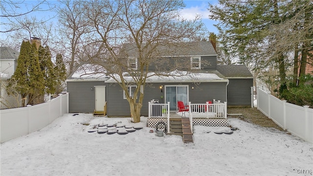 rear view of house with a fenced backyard and a deck