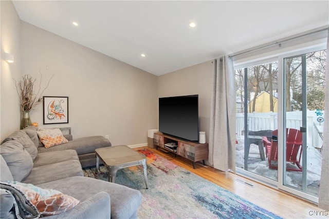 living area with recessed lighting, visible vents, vaulted ceiling, and light wood-style flooring