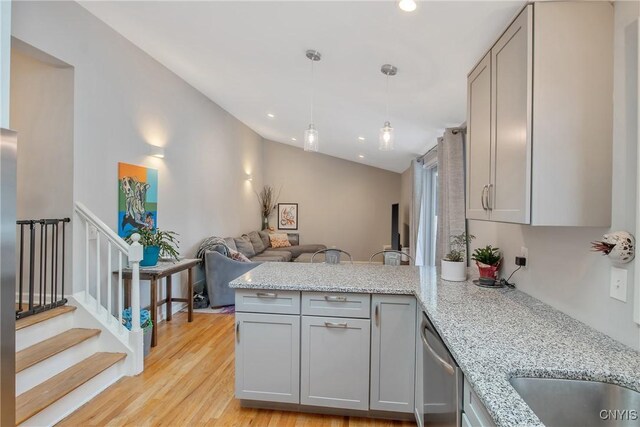 kitchen with lofted ceiling, light wood-style flooring, a peninsula, gray cabinets, and stainless steel dishwasher