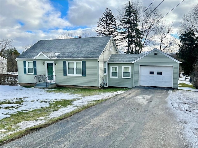 ranch-style home with a garage, aphalt driveway, and roof with shingles