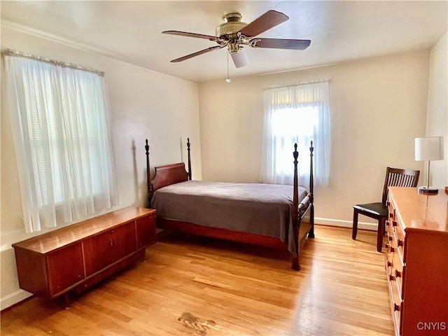 bedroom with light wood finished floors, ceiling fan, and baseboards