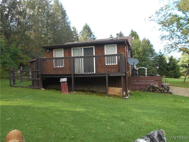 back of house featuring a lawn and a deck