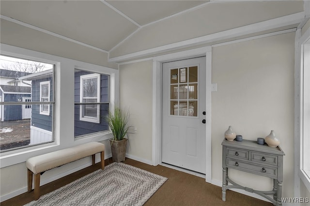 doorway to outside featuring baseboards, vaulted ceiling, and a wealth of natural light