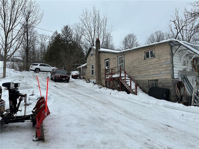 snow covered property with a chimney