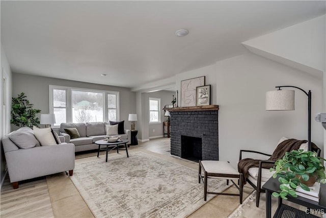 living area with a brick fireplace and light wood finished floors