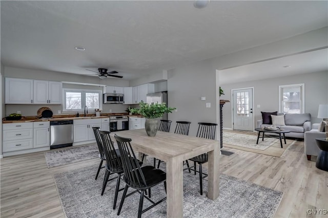 dining room with ceiling fan and light wood finished floors