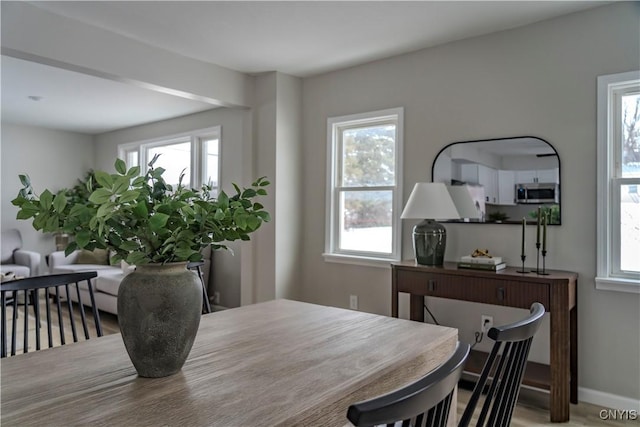 dining space with wood finished floors and baseboards