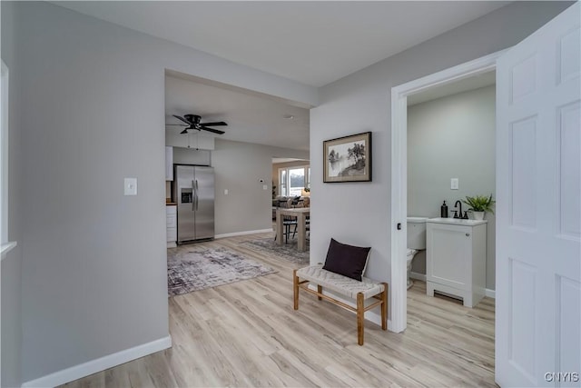 hallway featuring light wood-style flooring and baseboards