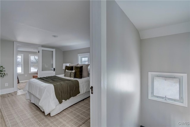 bedroom with multiple windows, baseboards, and vaulted ceiling