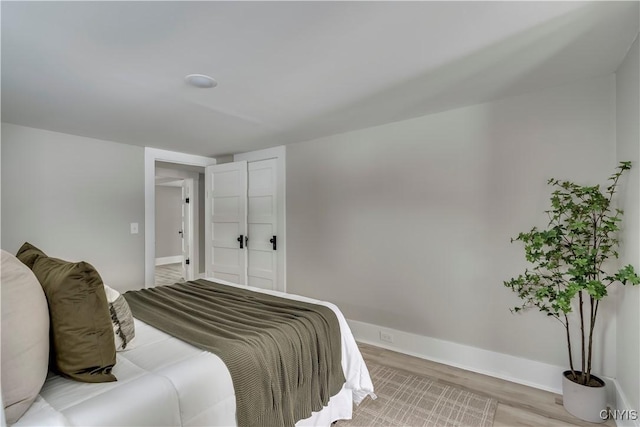 bedroom with light wood finished floors and baseboards