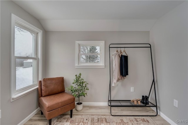 sitting room with vaulted ceiling, baseboards, and wood finished floors