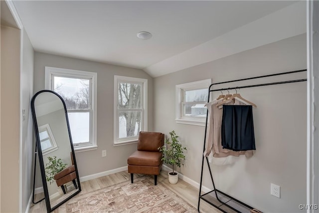 sitting room featuring lofted ceiling, baseboards, and wood finished floors