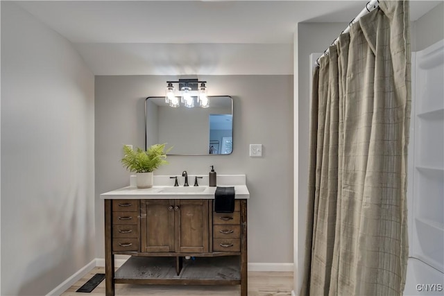 full bath featuring visible vents, baseboards, wood finished floors, and vanity