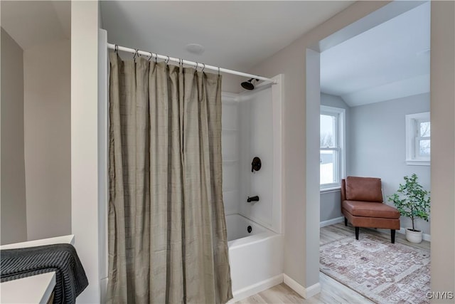 full bath featuring lofted ceiling, shower / tub combo with curtain, baseboards, and wood finished floors