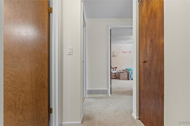 corridor with carpet floors, baseboards, and visible vents