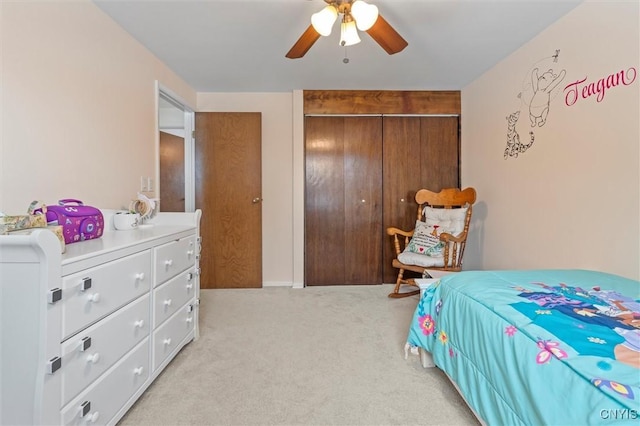 bedroom featuring light carpet, ceiling fan, and a closet